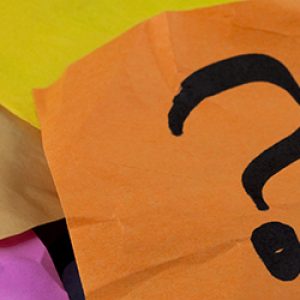 questions, decision making or uncertainty concept - a pile of colorful crumpled sticky notes with question marks