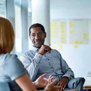 Shot of two colleagues talking together in a modern office